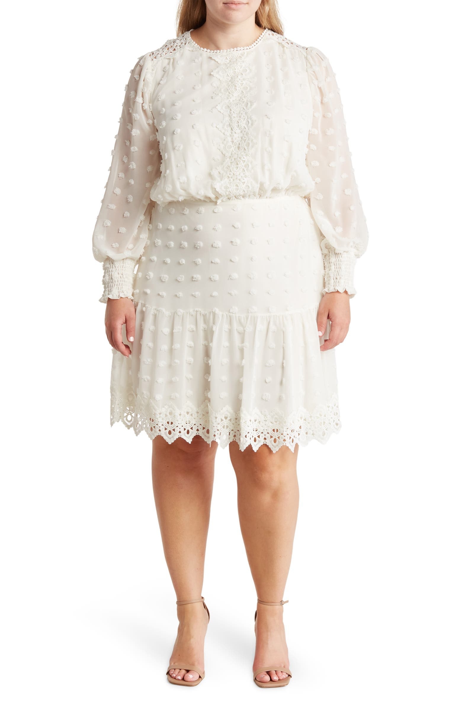 model in white knee-length dress and long sheer sleeves with embroidered textured dots covering it