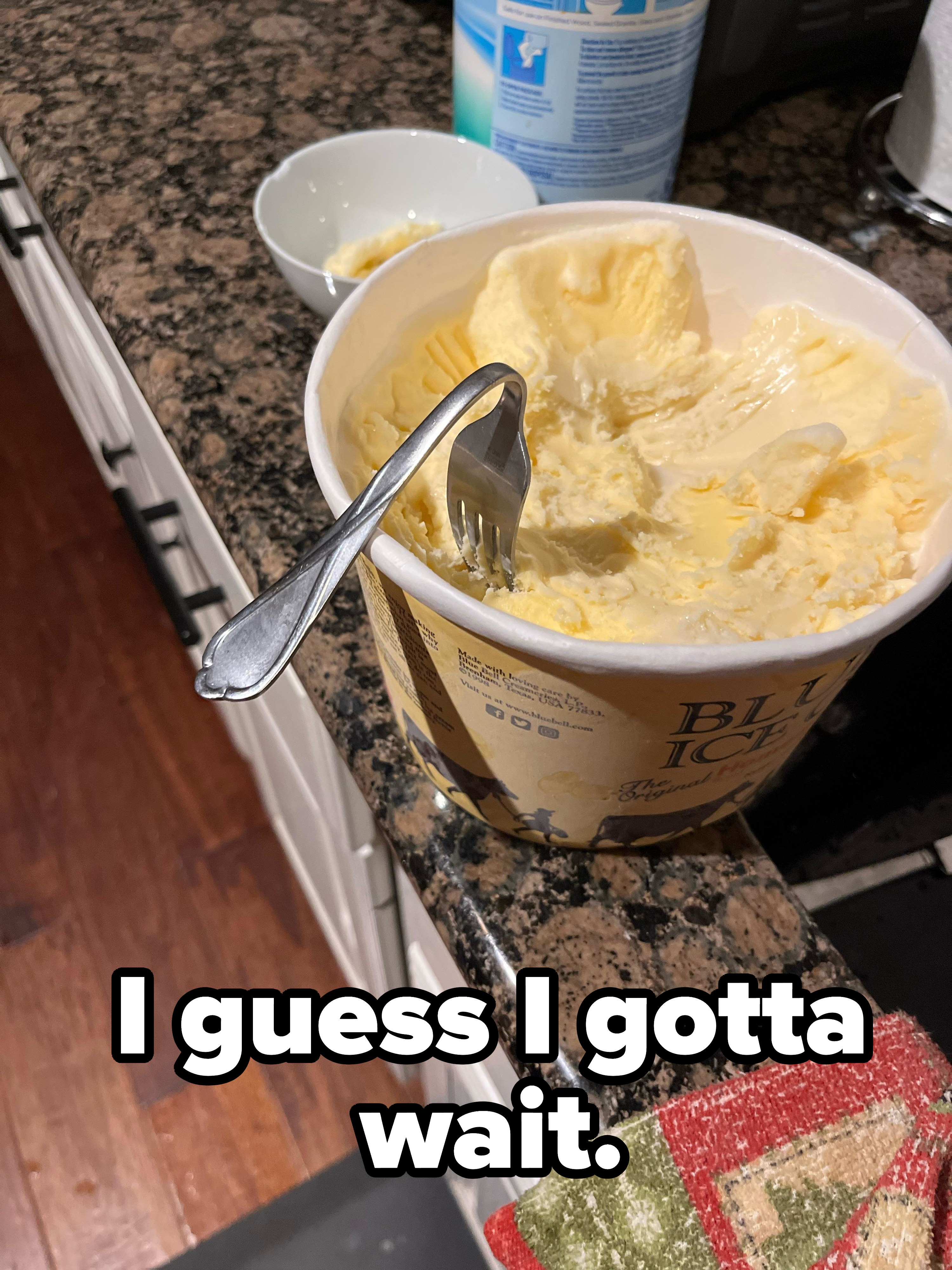 a bent fork in ice cream and the words &quot;I guess I gotta wait&quot;