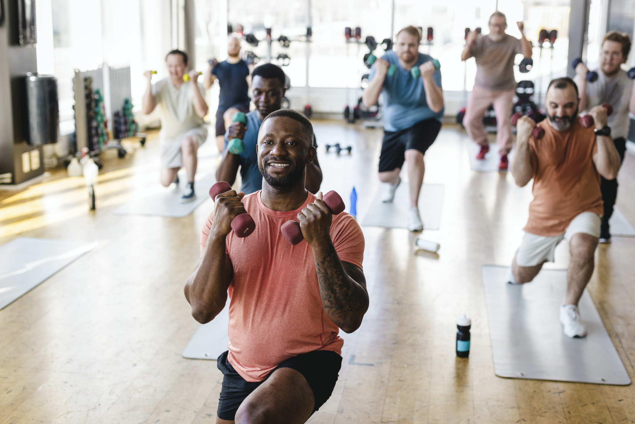 A man leads a workout class with small hand weights