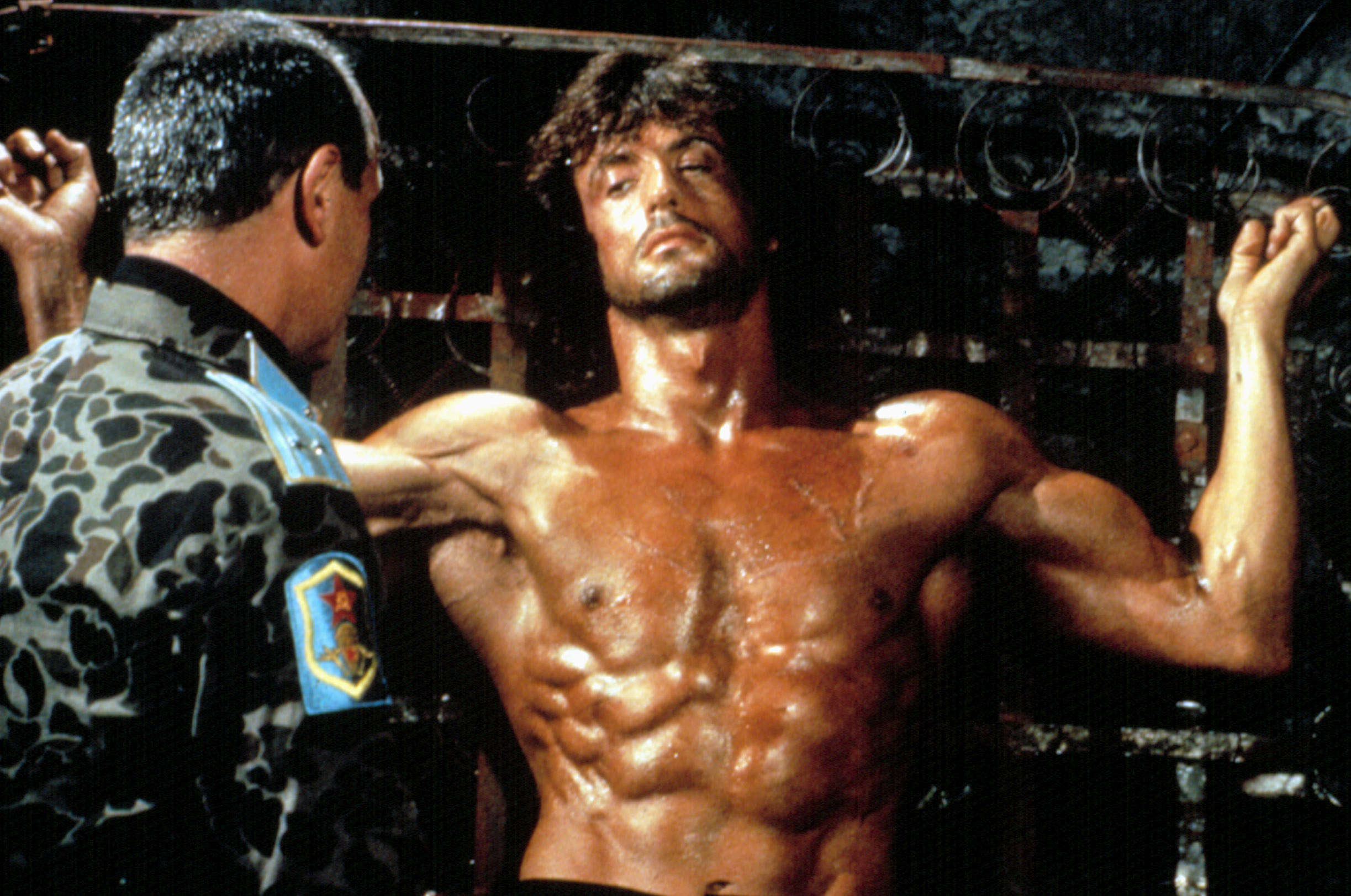 A shirtless man speaks to an officer
