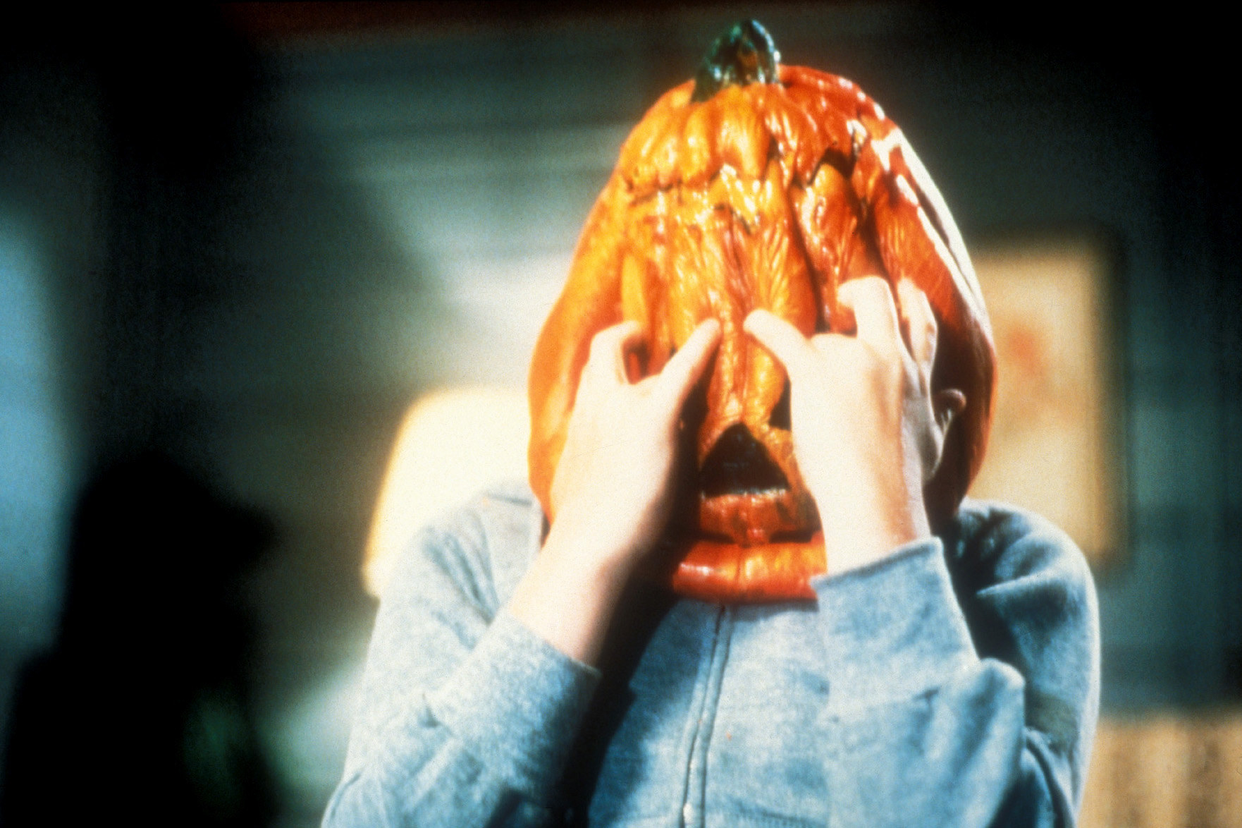A child with a pumpkin on their head