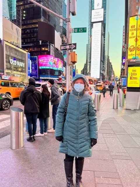 A reviewer wearing a blue coat in NYC