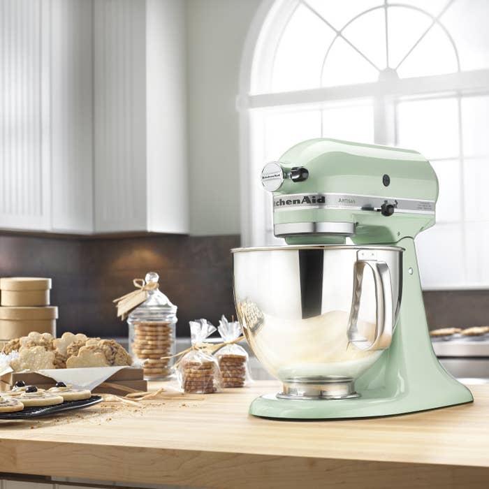 The mixer on a countertop next to cookies