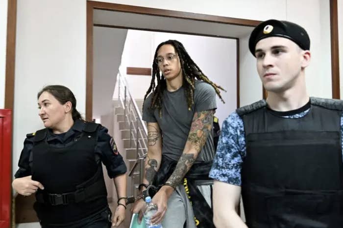 Brittney Griner in handcuffs flanked by guards on the way to court