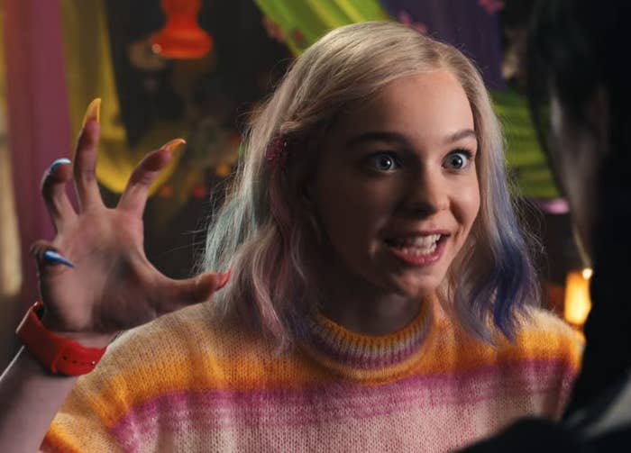 Enid rocks colorful fingernails an a purple and orange gradient sweater