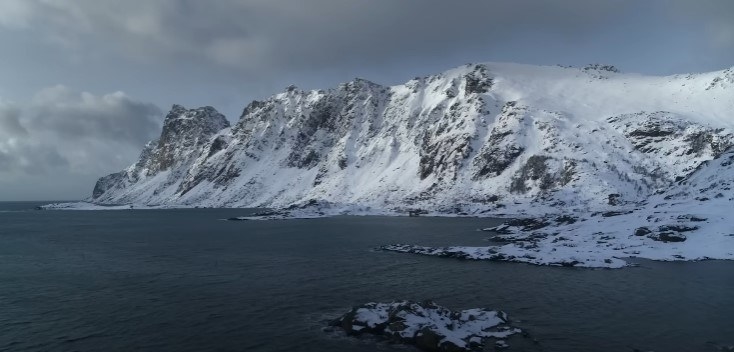 A landscape shot of icy mountains lining the sea