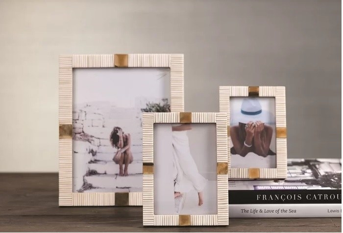 Three photo frames on top of a stack of books