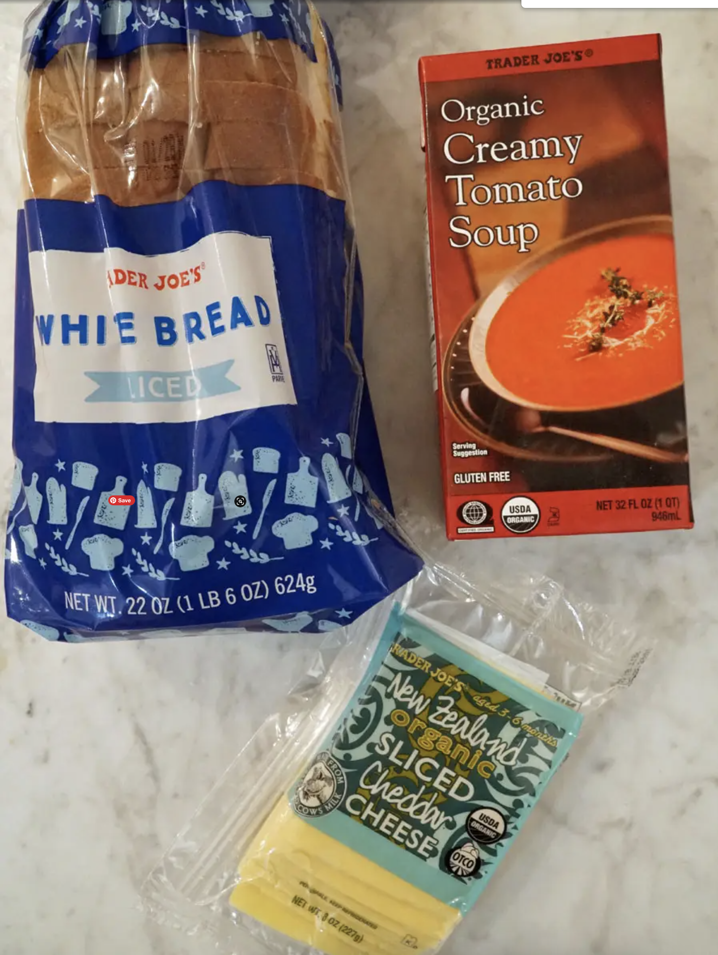Trader Joe&#x27;s containers of tomato soup, bread, and sliced cheddar cheese