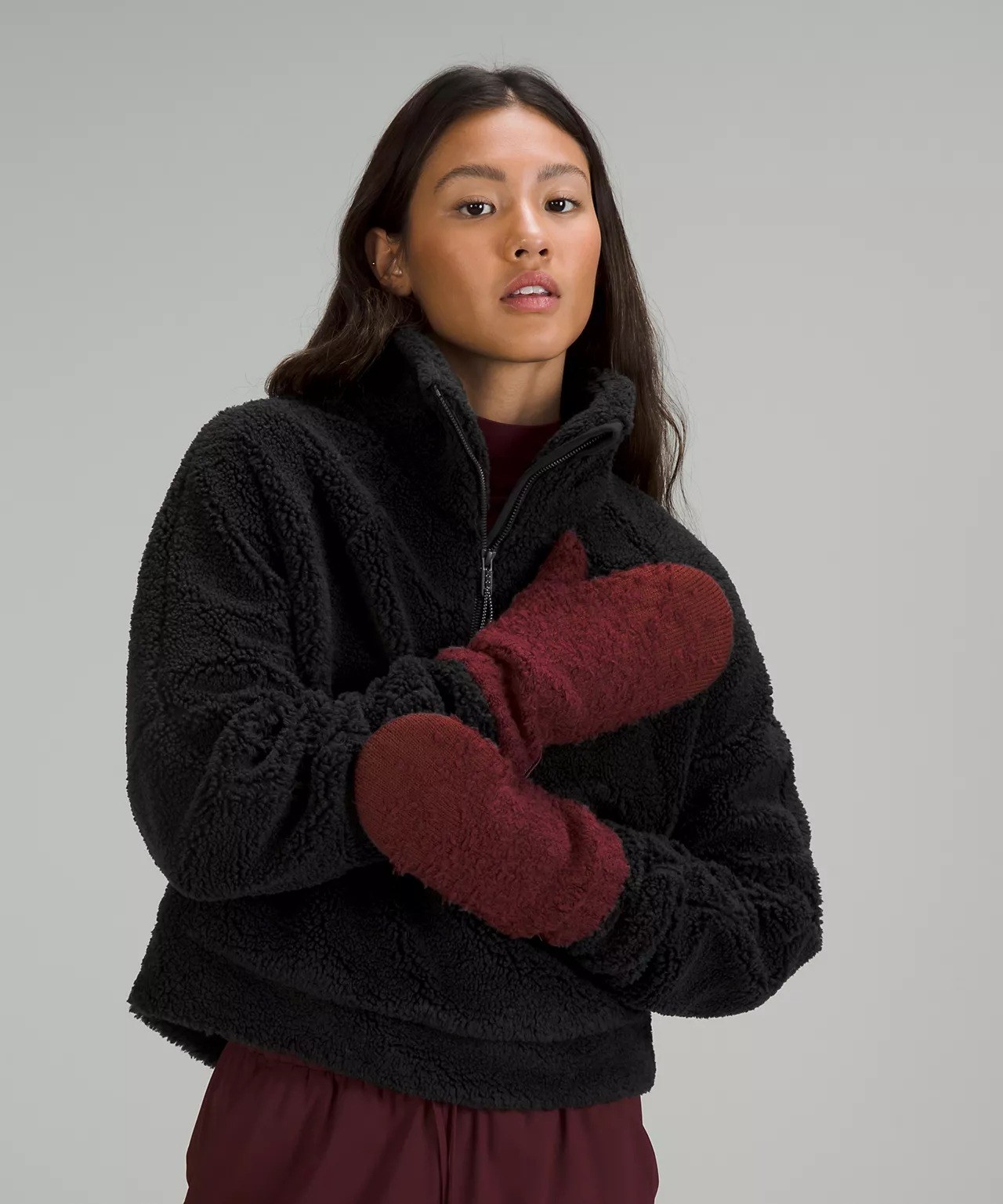a model wearing the burgundy mittens