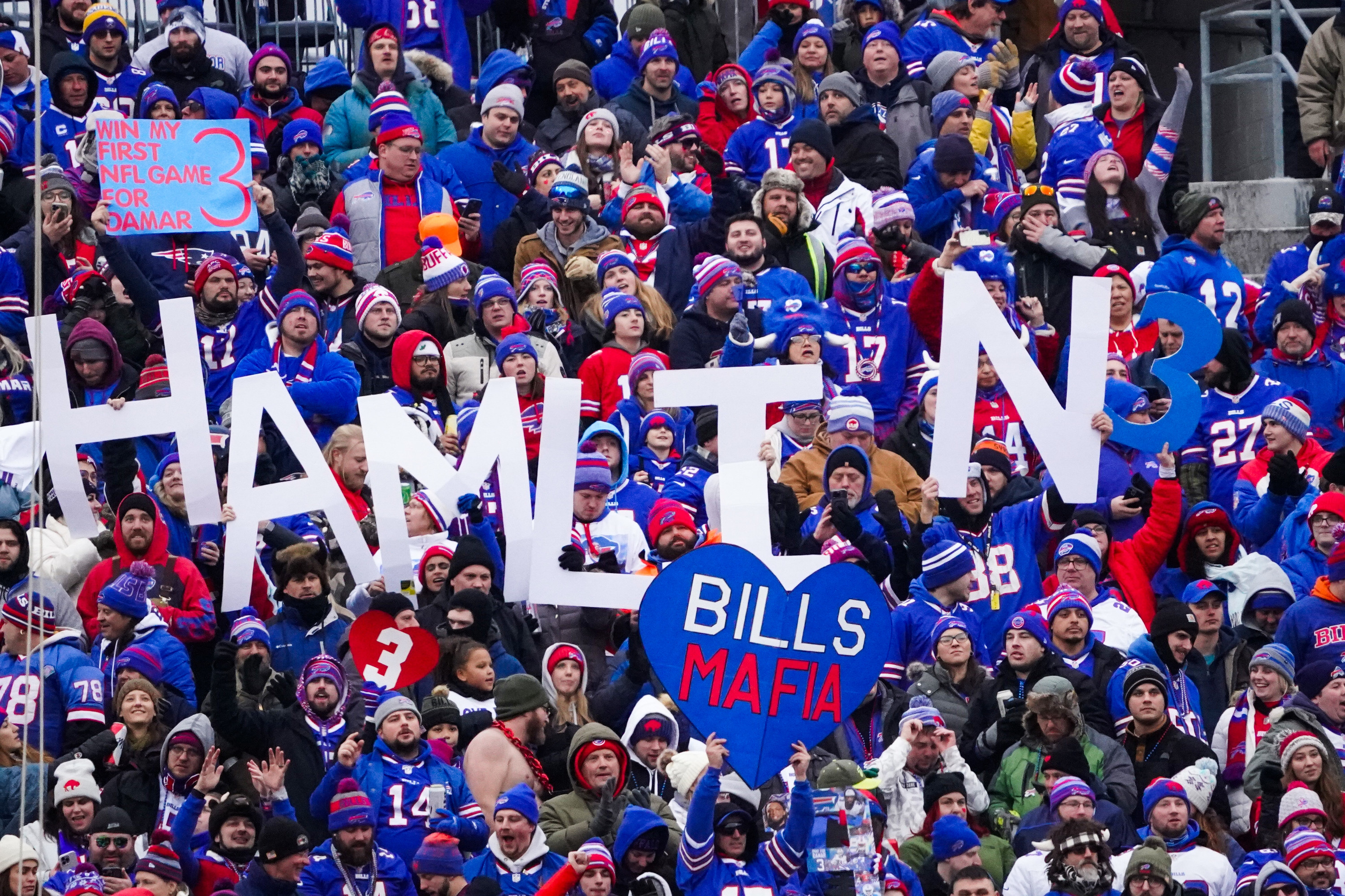 Buffalo Bills fans hold up signs in support of Damar Hamlin during their regular season finale against the New England Patriots