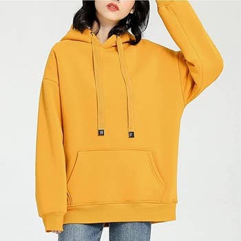 a model wearing the yellow hoodie