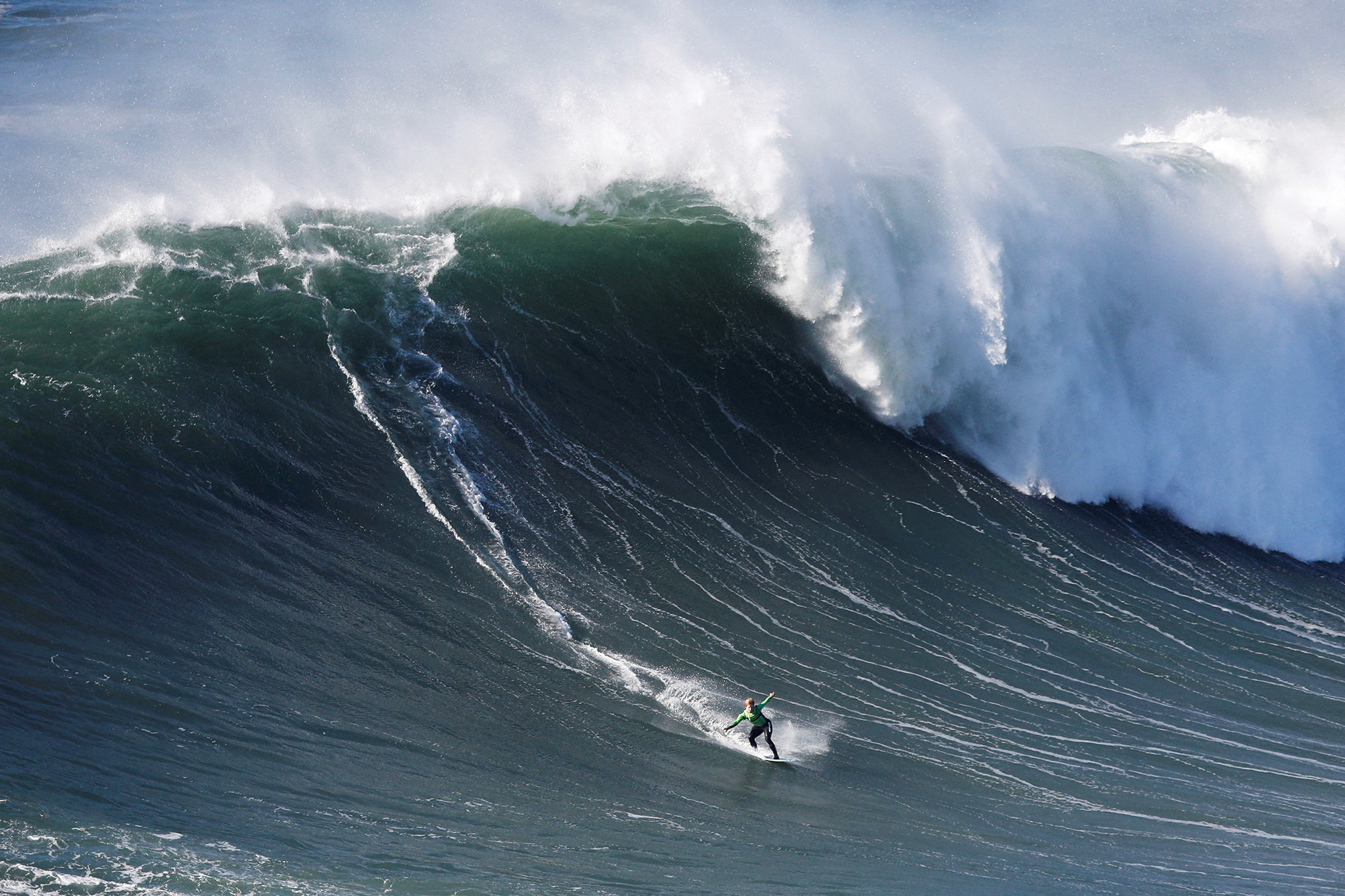 someone shredding on a hugeeeeeee blue wave