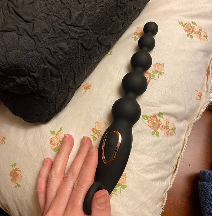Reviewer holding black beaded anal plug
