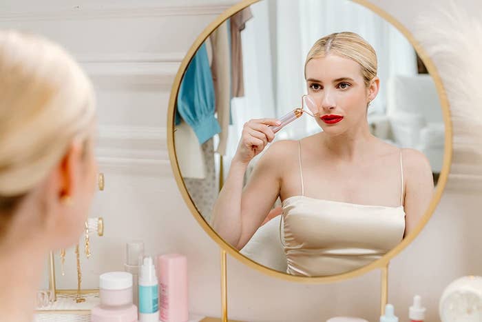 Emma Roberts using the roller in a mirror