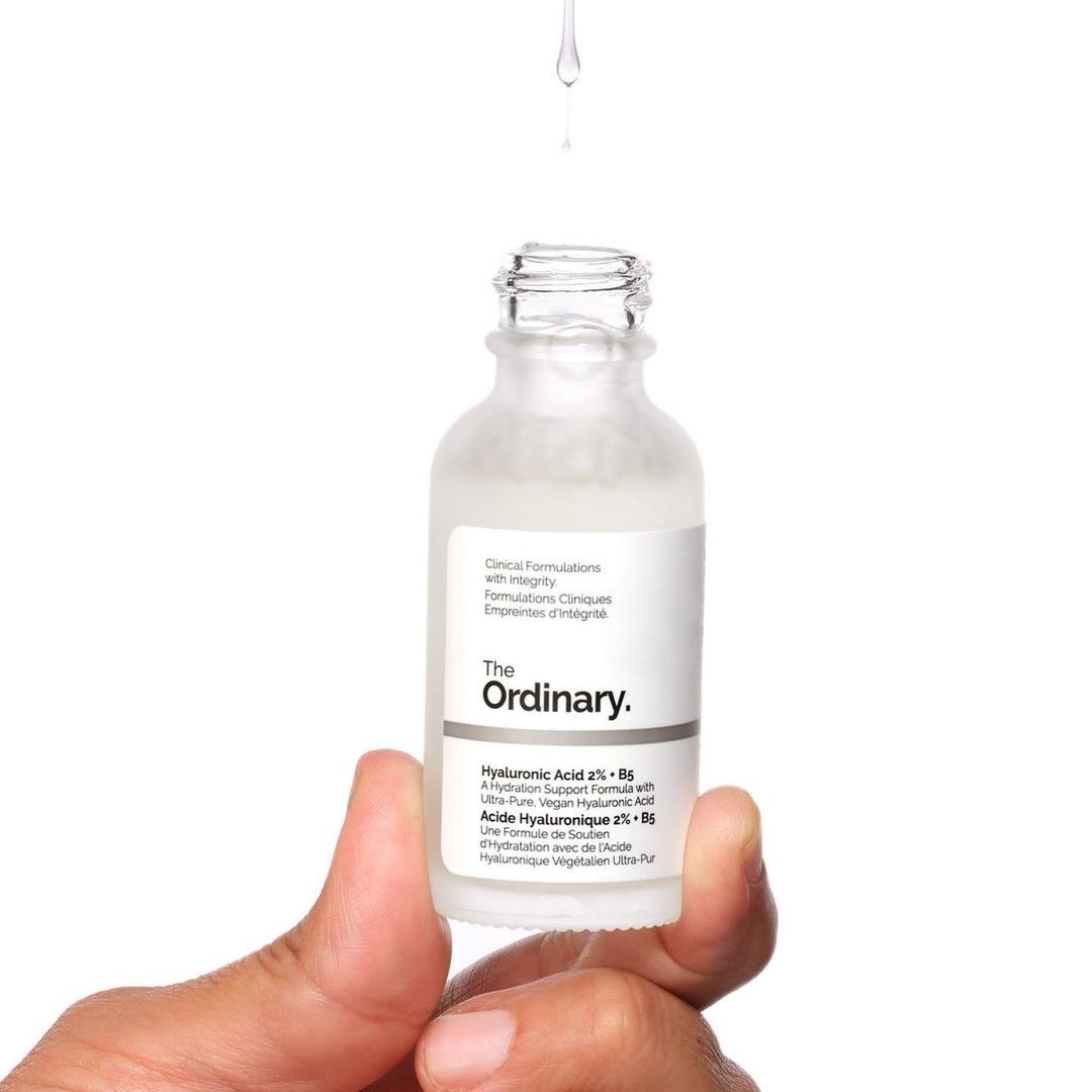 a person holding up a bottle of the hydrating serum