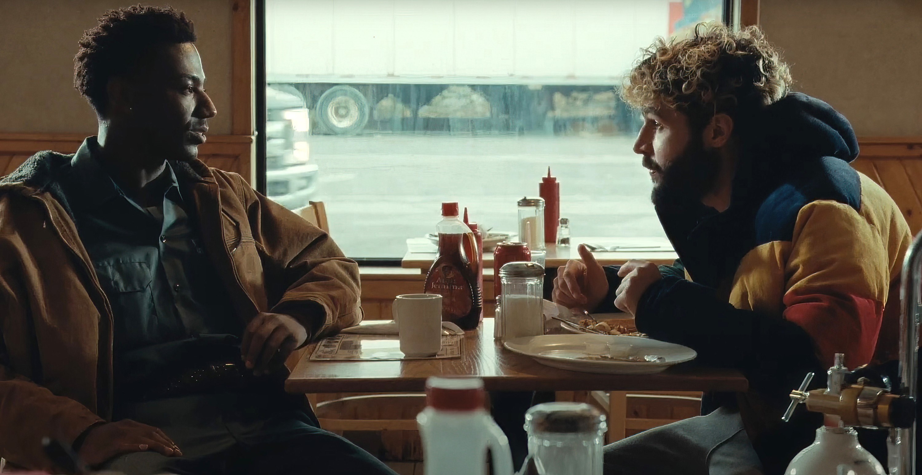 Jerrod and Christopher sit across from one another at a diner in a scene from On the Count of Three
