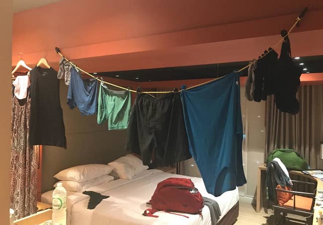 a reviewer photo of the clothesline hanging in a hotel room with clothes hanging on it
