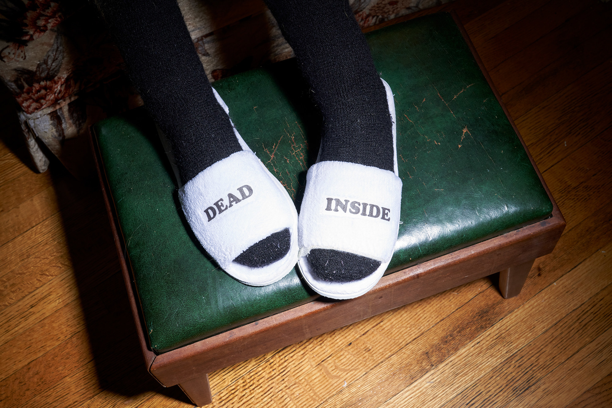 socked feet in slippers that say &quot;dead&quot; and &quot;inside&quot; 