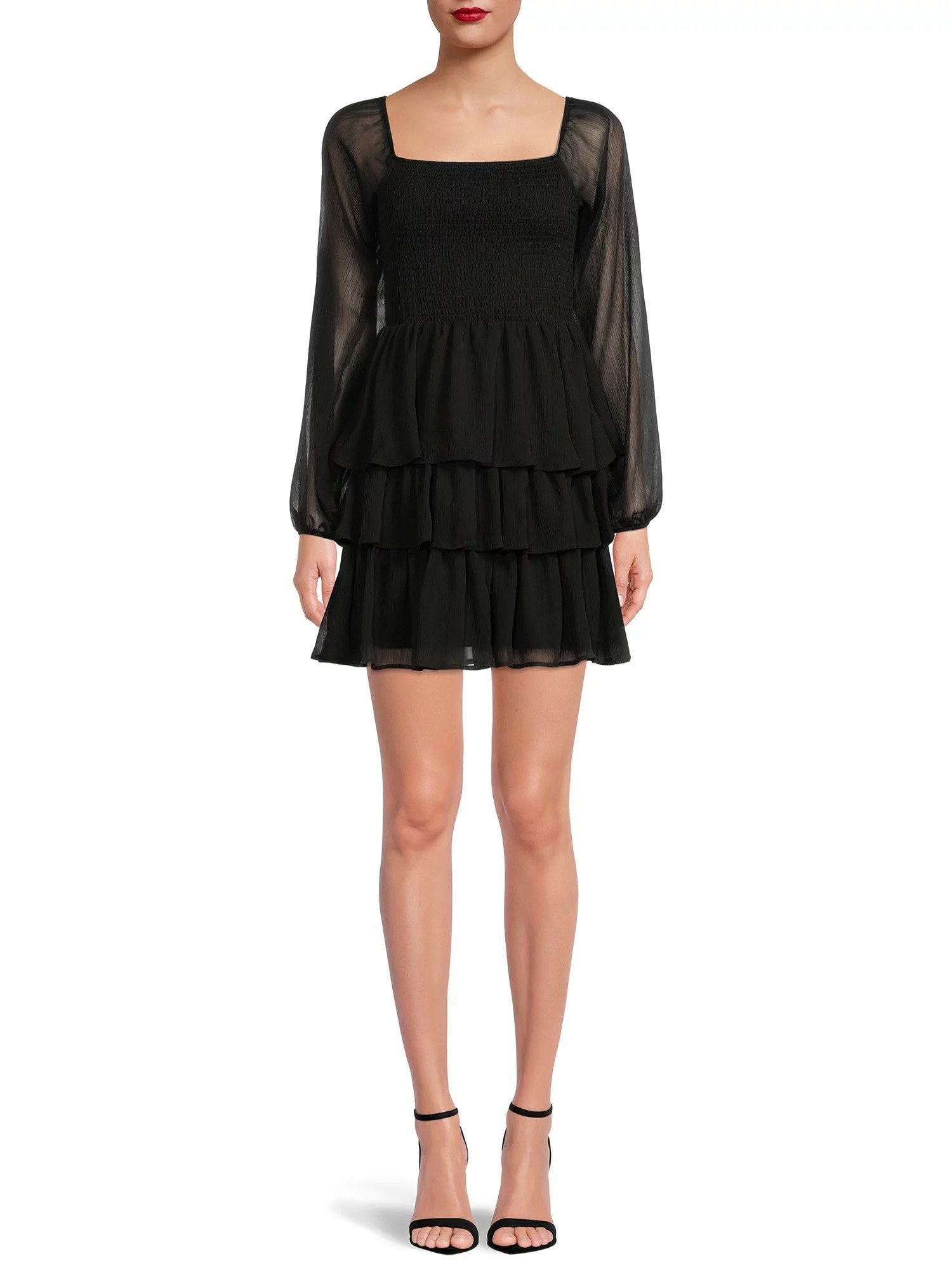Model wearing black three tiered mini dress with long sheer sleeves