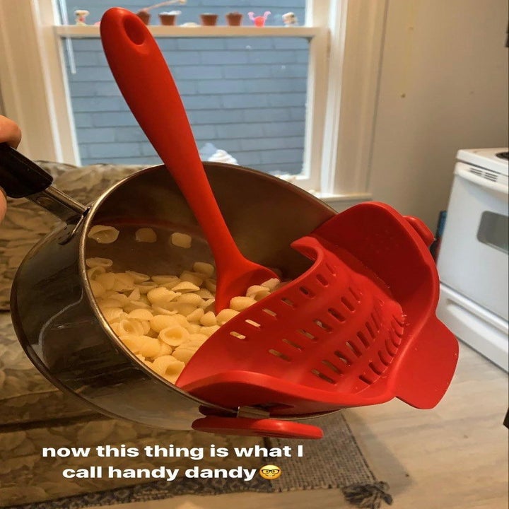 reviewer's pot full of posta with the red strainer attached