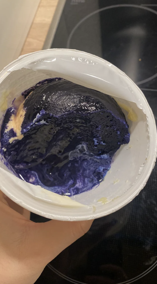 Ricotta in a container with a dark purplish blue on top