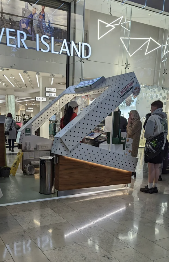 A mall donut shop kiosk in the shape of a Krispy Kreme box