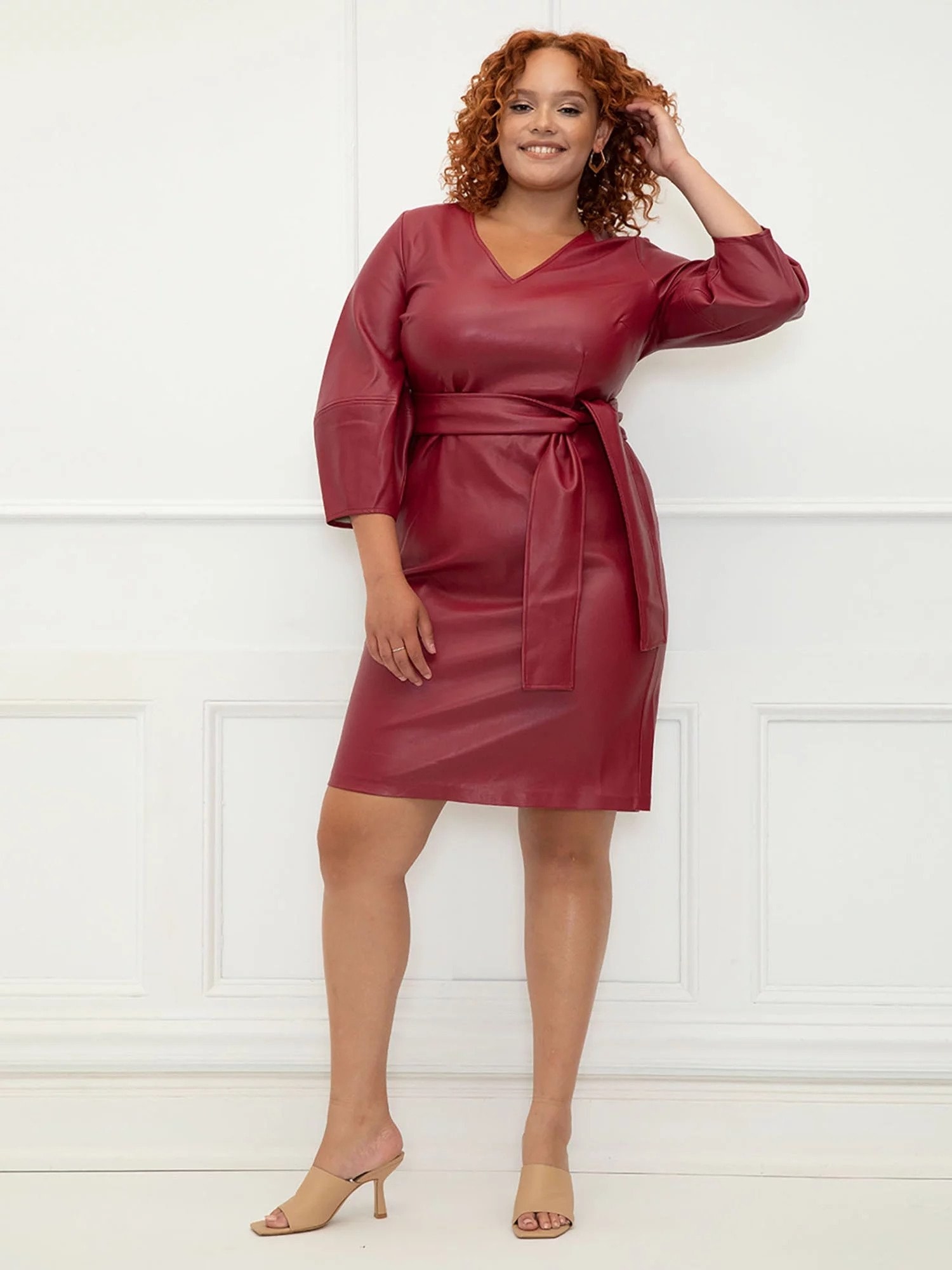 Model wearing red faux leather wrap dress