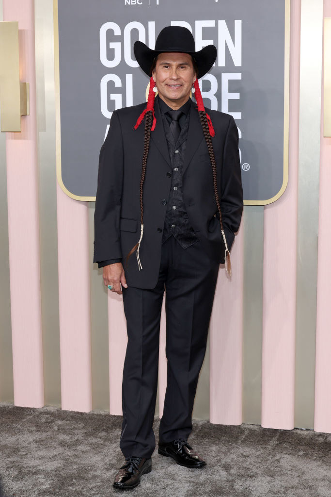 Mo Brings Plenty attends the 80th Annual Golden Globe Awards in a suit with red accents