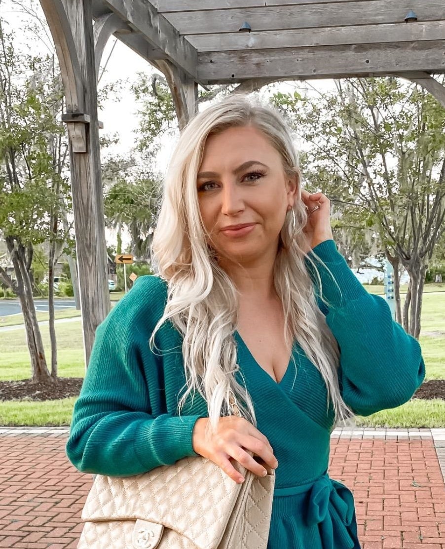reviewer wearing turquoise wrap sweater