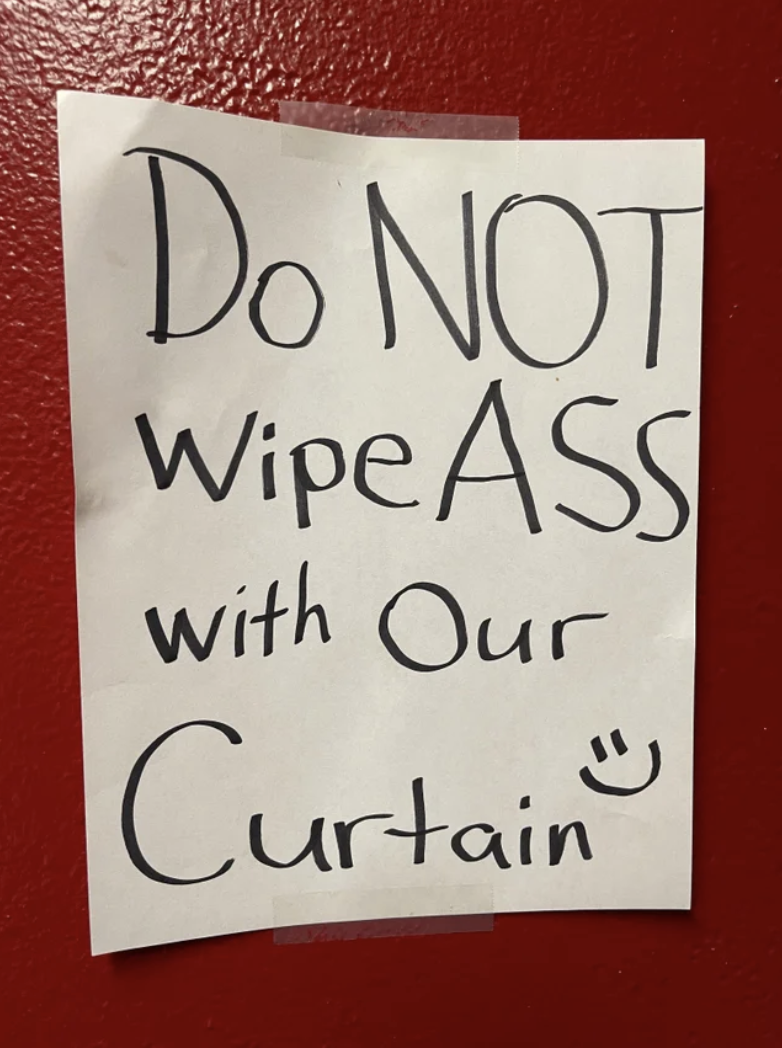 The sign says &quot;do not wipe ass with our curtain&quot; with a smiley face drawn at the end