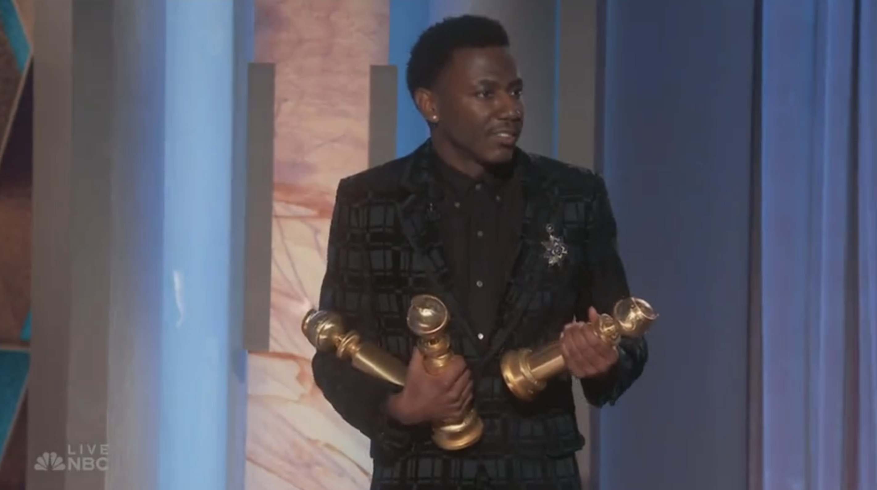 Jerrod holding the three awards on stage