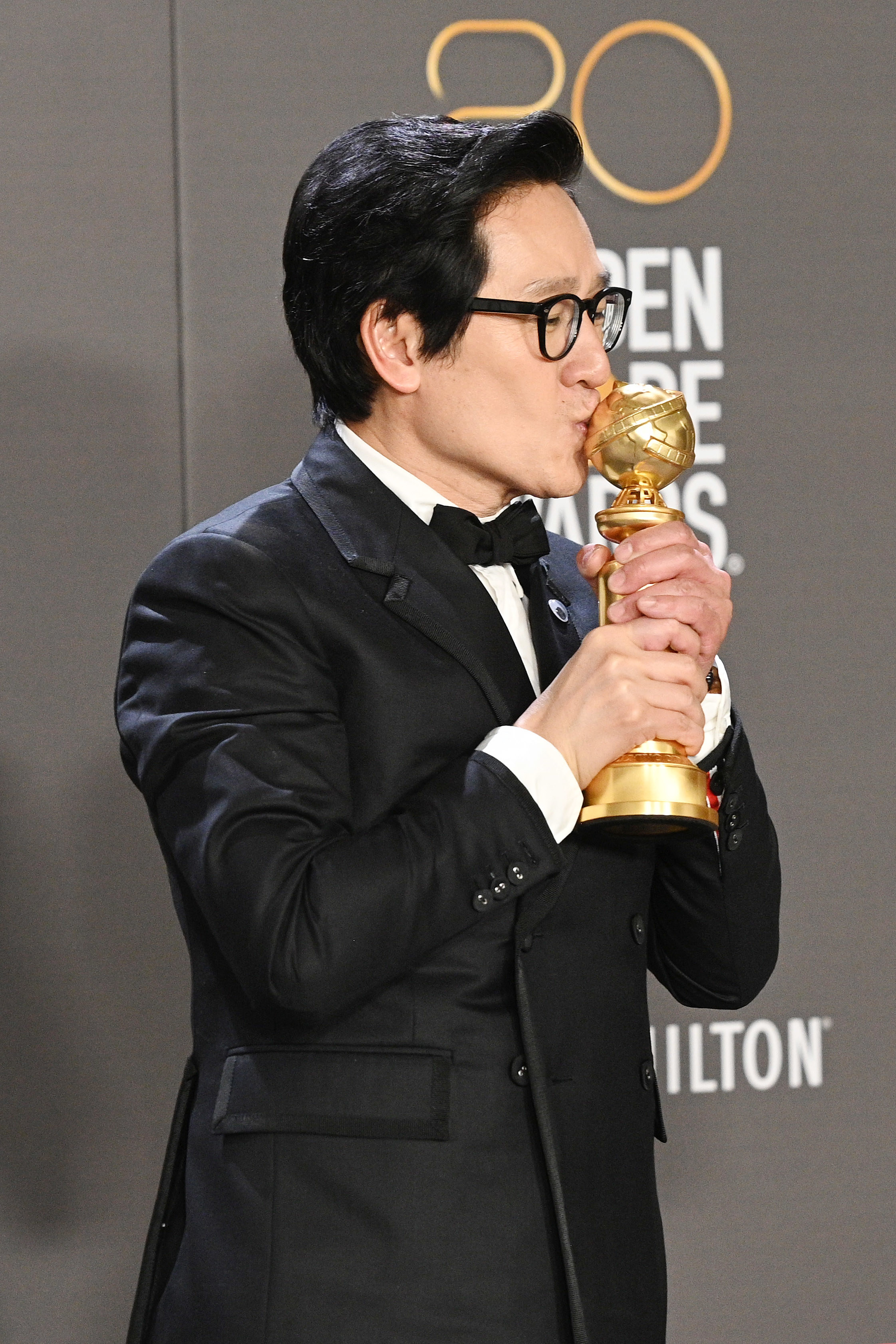 Ke Huy Quan kisses his award backstage