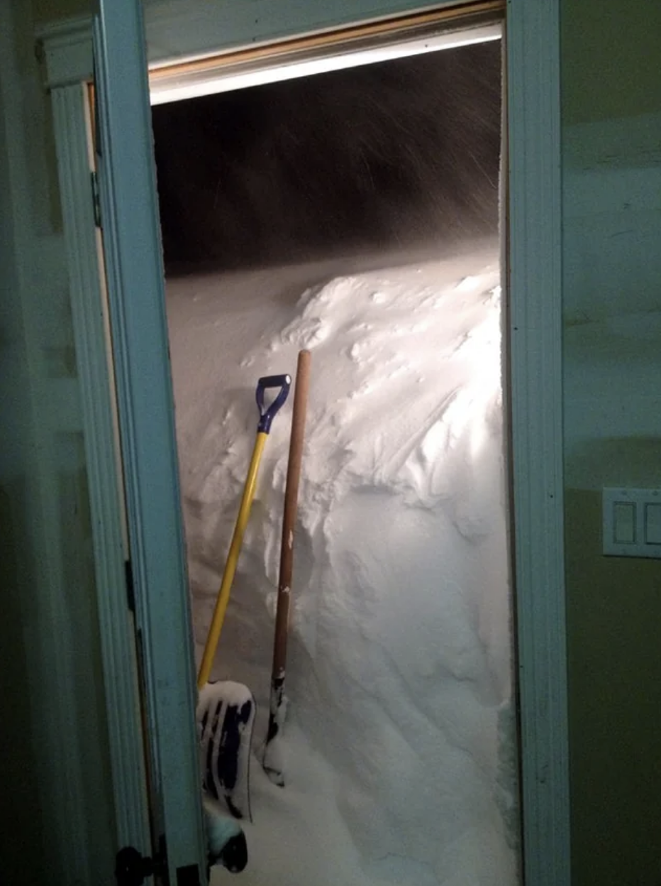 A doorway completely covered in snow