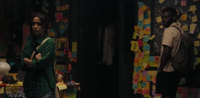 A man and woman examine a room full of post-it notes