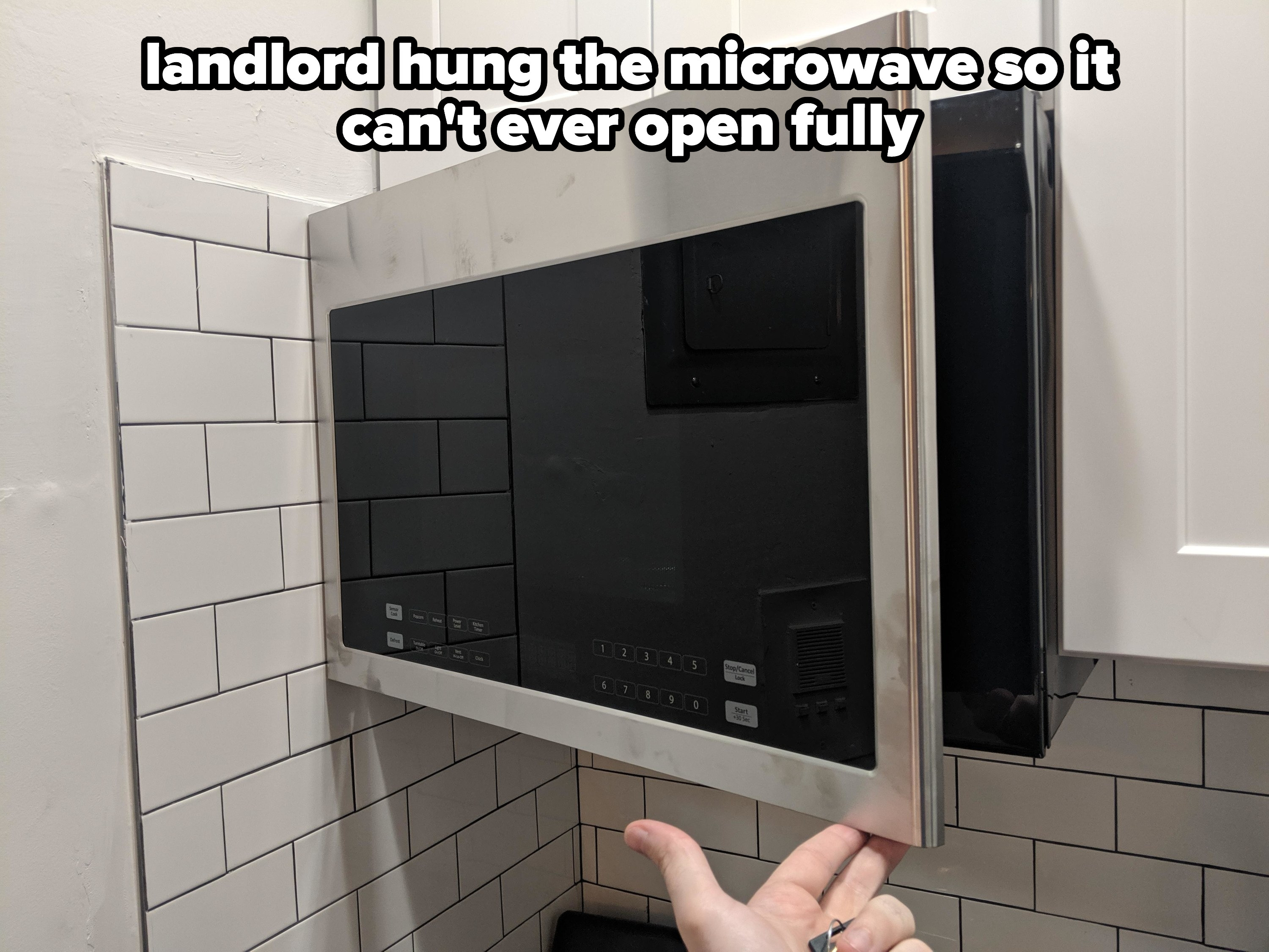 microwave installed right next to a wall so it cannot open fully