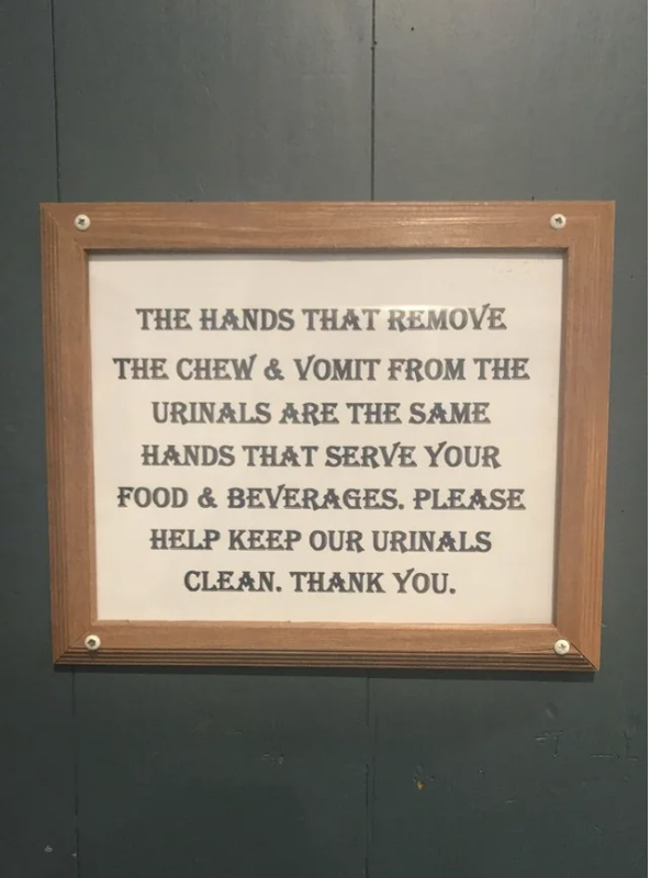 The sign says "the hands that remove the chew and vomit from the urinals are the same hands that serve your food and beverages, keep our urinals clean"