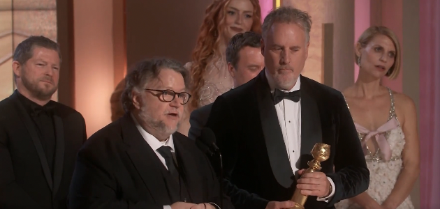 claire standing behind award winners looking unamused