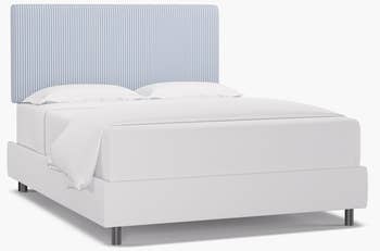 a bed with a blue and white striped headboard