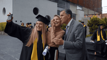 graduating student taking selfie with parents