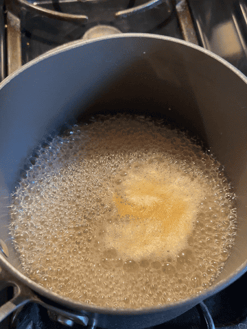gif of adding pastina pasta to boiling water in saucepan