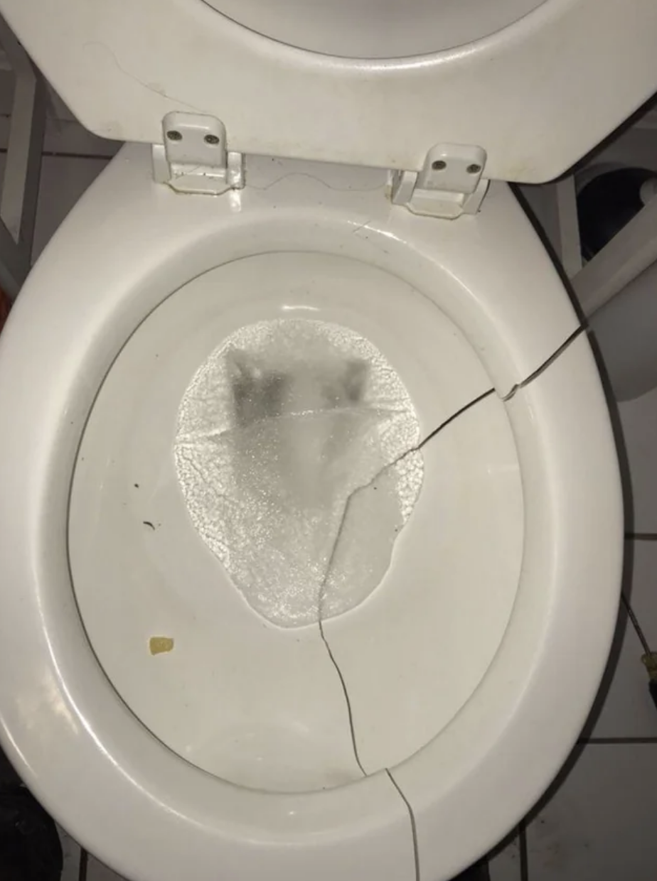A broken toilet with frozen toilet water