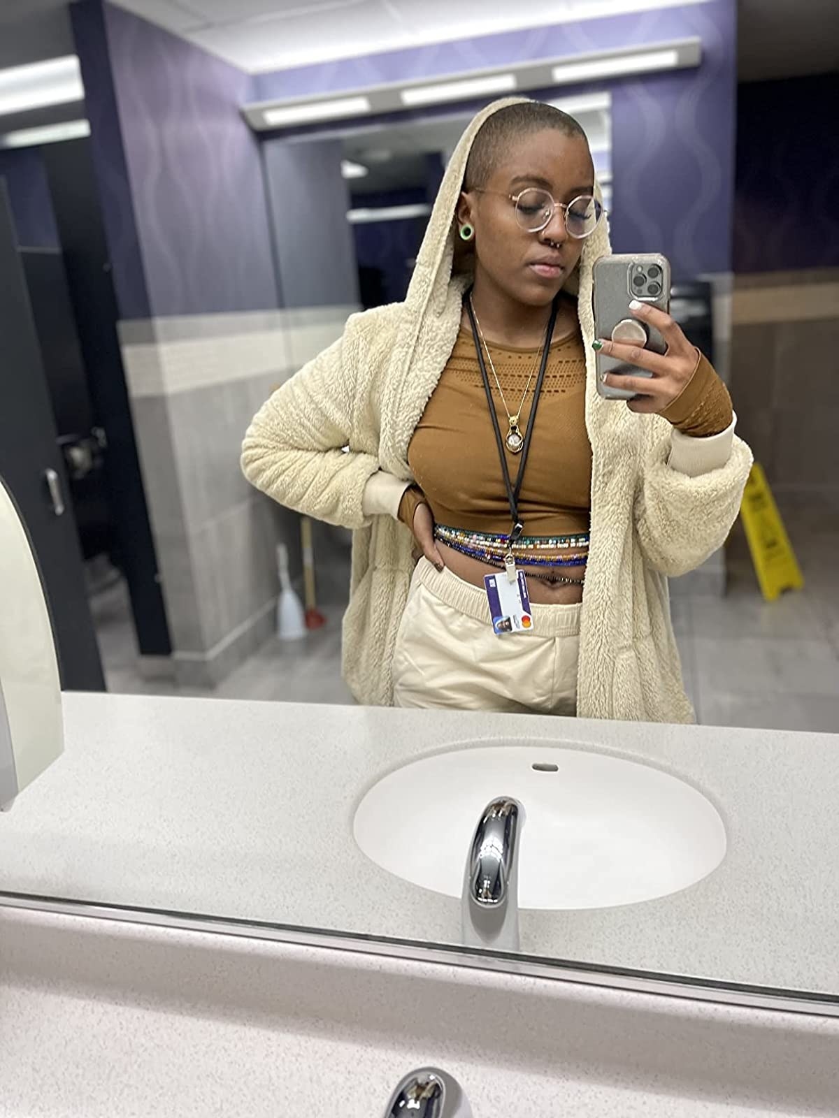 Reviewer wearing beige fuzzy cardigan over brown shirt and beige pants