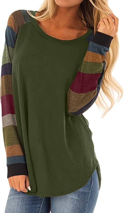 Model wearing green tunic with multicolor striped sleeves
