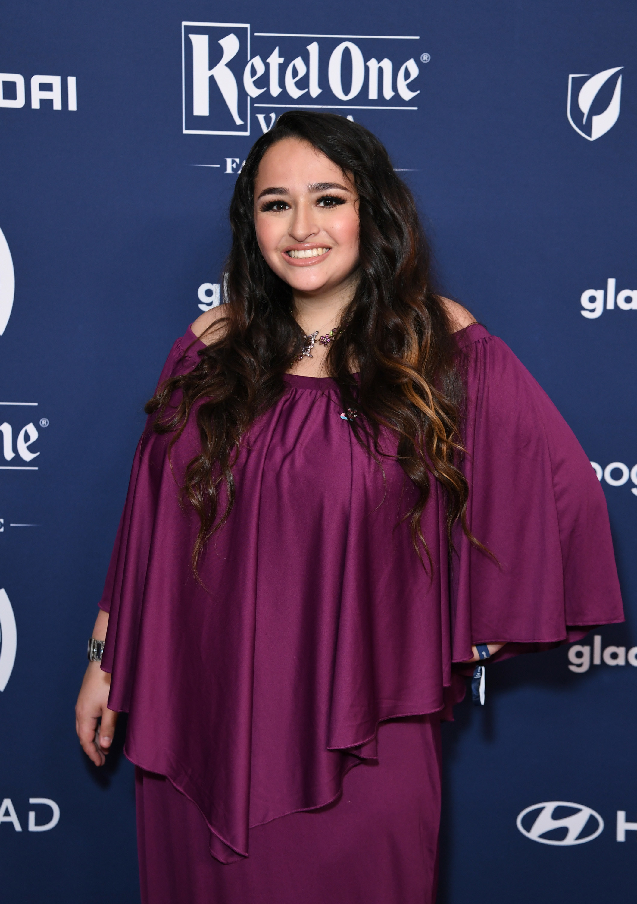 Smiling Jazz on the red carpet in a flowy, off-the-shoulder top and matching bottoms