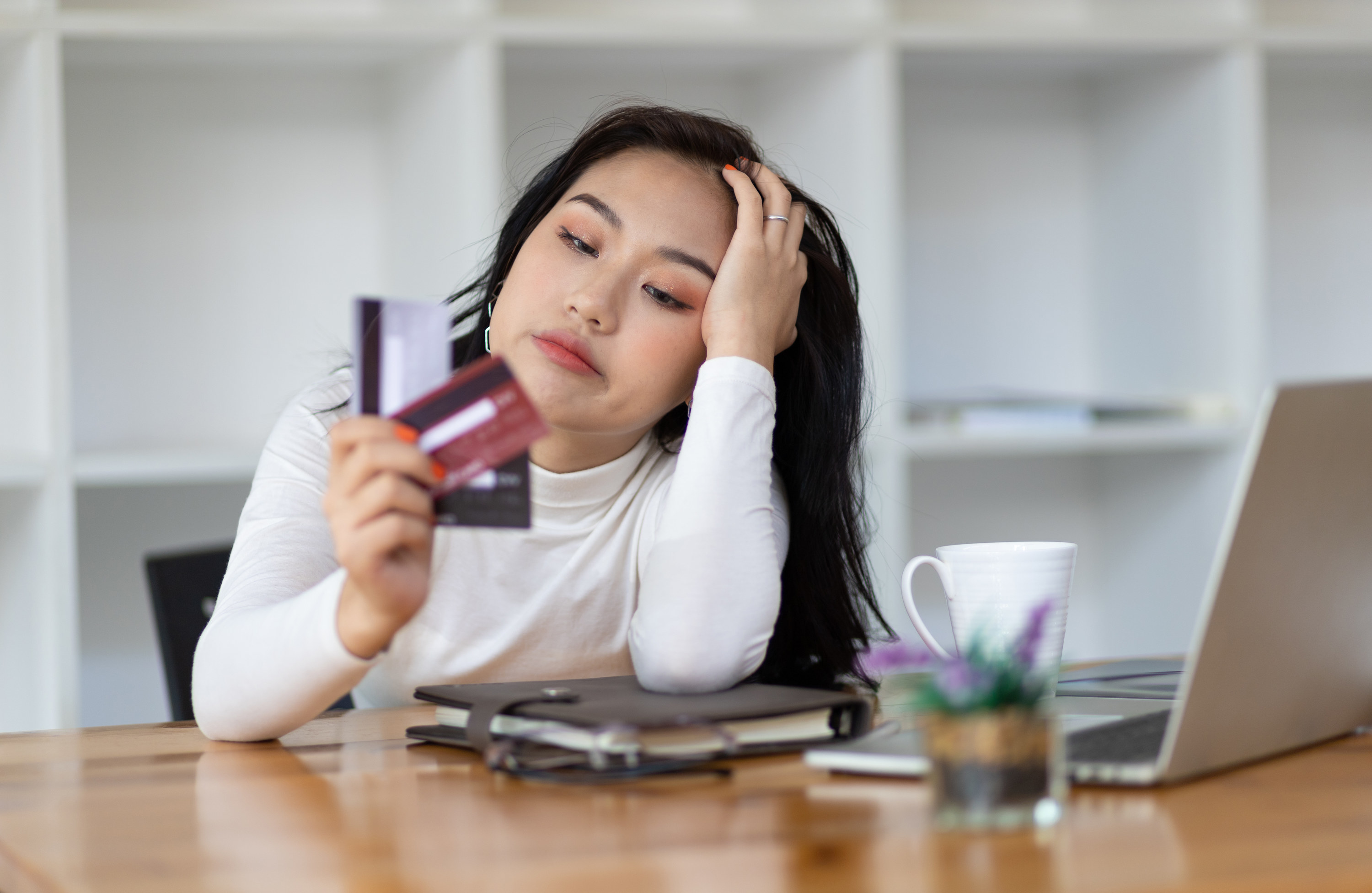 stressed out woman looking at her credit cards
