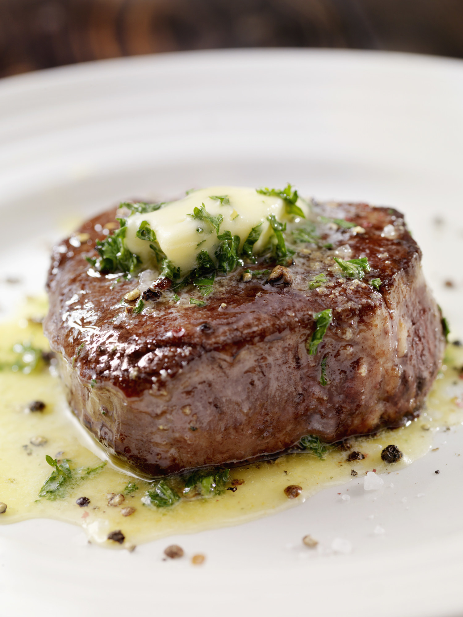 Butter and some garnish on top of a cooked steak