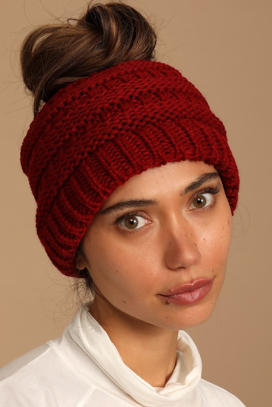 model wearing red cable knit beanie