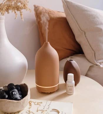 the stone diffuser in terracotta sitting on a  bedside table