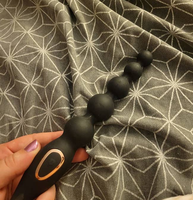 reviewer holding black graduated vibrating anal beads