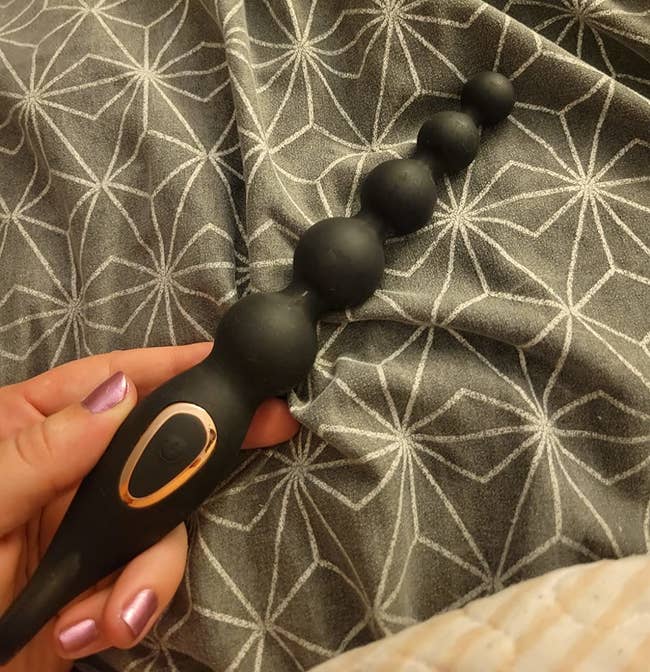 reviewer holding black graduated vibrating anal beads